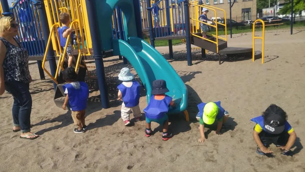 Des enfants de la garderie jouent dans le sable au parc